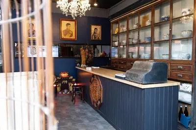 a restaurant with a counter in a room at Orange Lodge in Bangkok