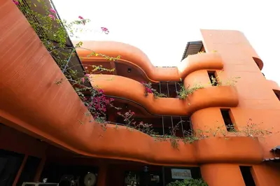 an orange building with plants on the side of it at Orange Lodge in Bangkok