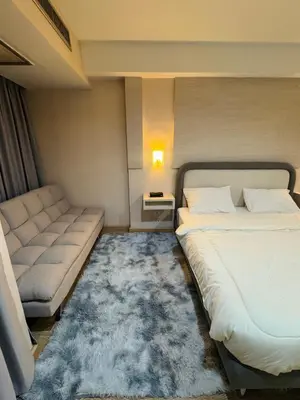 a bedroom with a bed and a couch and a rug at Inspire place rama9 Modern Condo near Rajamangala Stadium Pool and Gym in Bangkok