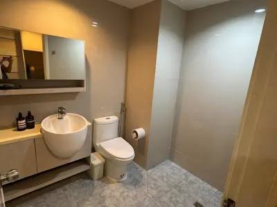 a bathroom with a sink and a toilet and a mirror at Inspire place rama9 Modern Condo near Rajamangala Stadium Pool and Gym in Bangkok