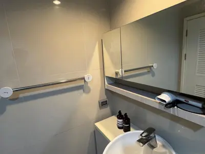 a bathroom with a sink and a mirror at Inspire place rama9 Modern Condo near Rajamangala Stadium Pool and Gym in Bangkok