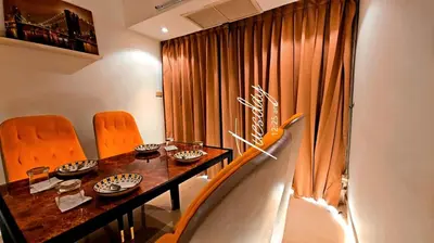 a dining room with a table and orange chairs at River View 8 in Yan Nawa