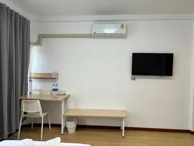 a room with a desk and a tv on a wall at M3 Bangkok Bake & Bed in Bangkok