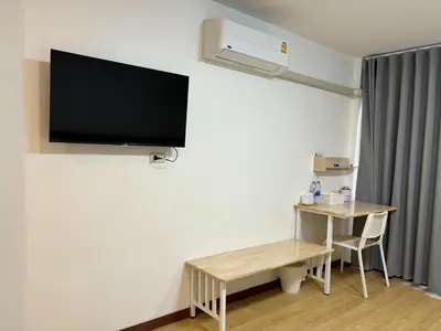 a room with a desk and a tv on the wall at M3 Bangkok Bake & Bed in Bangkok