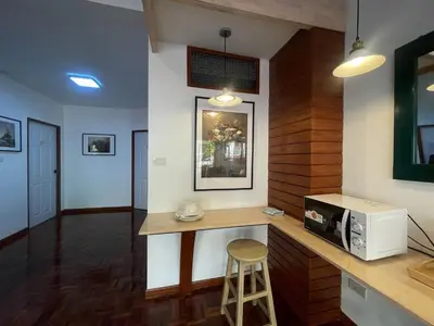 a kitchen with a counter with a microwave and a stool at M3 Bangkok Bake & Bed in Bangkok