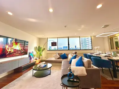 a living room with a couch and a tv and a table at Luxury 3 bedrooms in the heart of the city in Bangkok