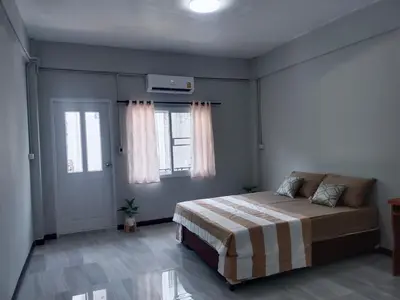 a bedroom with a bed and two windows at The little home in Bangkok