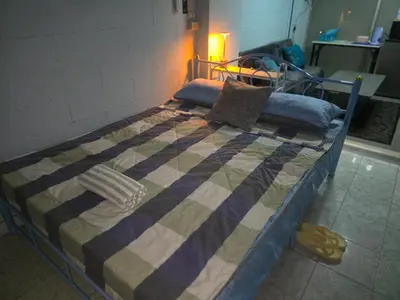 a bed with a quilt on it in a room at Beautiful Studio 107 Apartment with nice living room with WiFi in Bangkok