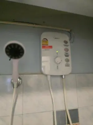 a bathroom with a fan and a wall at Beautiful Studio 107 Apartment with nice living room with WiFi in Bangkok