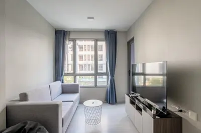 a living room with a couch and a tv at 1BR Apt - Pool, Gym, Rooftop, BTS, Coworking Space - 10 min Nana Plaza - Central - New Building - 24 7 Security in Bangkok