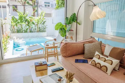 a living room with a couch and a pool at \u66fc\u8c37\u5e02\u4e2d\u5fc3\u56db\u5367\u5ba4\u6cf3\u6c60\u522b\u5885 in Bangkok