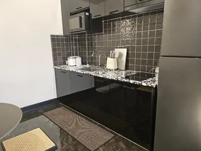 a kitchen with a black and white tiled wall at Soho Heritage House China Town Bangkok in Bangkok