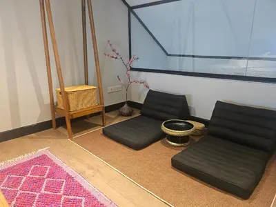 a living room with two chairs and a rug at Soho Heritage House China Town Bangkok in Bangkok