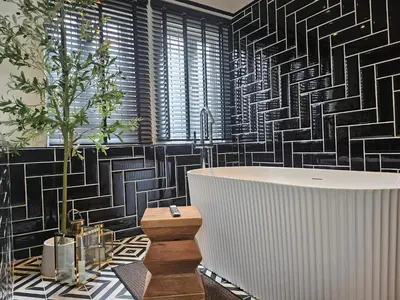 a bathroom with a tub and black and white tiles at Soho Heritage House China Town Bangkok in Bangkok