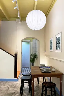 a dining room with a table and two stools at BaanBaan - Cozy home 5pax, 5min BTS, Boat, old town explore in Bangkok