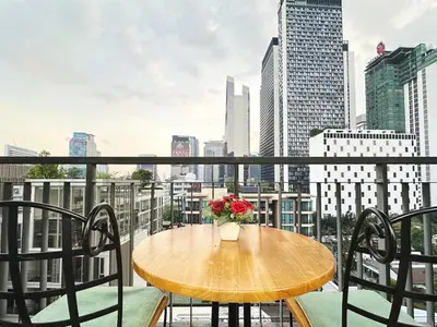 a table with a vase of flowers on a balcony at convenient&peaceful place in Soi nai leot in Bangkok