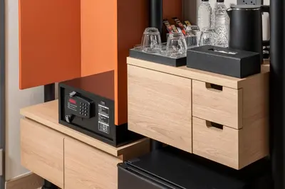a microwave oven sitting on top of wooden drawers at Asoka Hotel at Asoke Makkasan in Bangkok