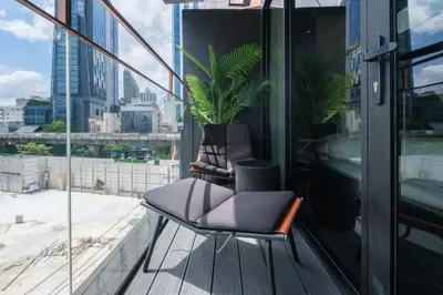 a balcony with two chairs and a potted plant at Hotel 433 - Asoke Sukhumvit in Bangkok