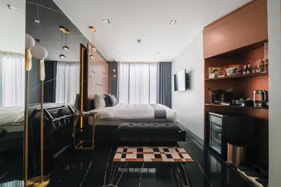 a bedroom with a king sized bed and a television at Hotel 433 - Asoke Sukhumvit in Bangkok