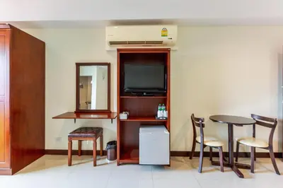 a room with a table and chairs and a television at Collection O VResotel in Nonthaburi