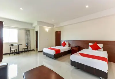 a hotel room with two beds and a table at Collection O VResotel in Nonthaburi