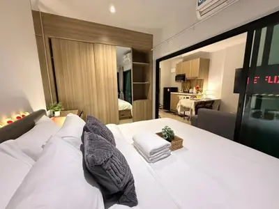 a bedroom with a white bed and a living room at คอนโดติด bts ตลาดพลู 0 เมตร ใกล้ Iconsiam ว่างรายเดือน in Thonhuri