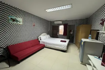 a living room with a red couch and a bed at Green Place 107 in Bangkok