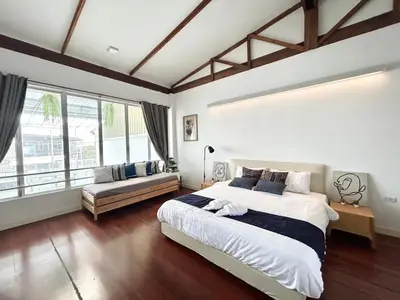 a bedroom with a large bed and a couch at Canal Villa on Onnut Road, near Bts Onnut, Bangkok in Amphoe Phra Khanong