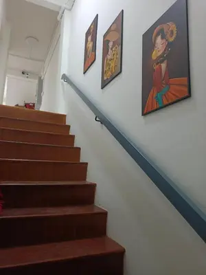a stairway with paintings on the wall and a stair case at The Little home in Ban Khlong Mae Nam Bon
