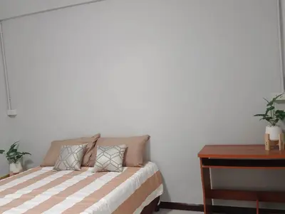 a bedroom with a bed and a desk and a table at The Little home in Ban Khlong Mae Nam Bon