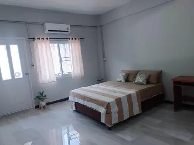 a bedroom with a bed in a room with windows at The Little home in Ban Khlong Mae Nam Bon