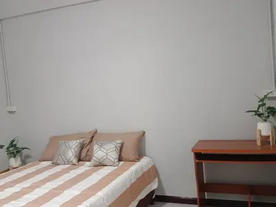 a bedroom with a bed and a desk and a table at The little home in Bang Mote