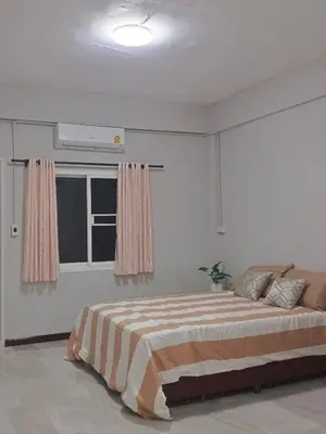 a white bedroom with a bed and a window at The little home in Bang Mote