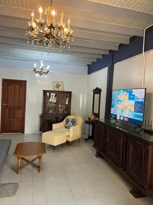 a living room with a couch and a tv and a chandelier at Baan Saen Saran residence in Sathani Bang Ramat