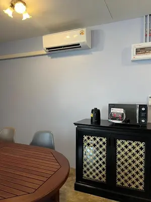 a room with a table and a air conditioner on the wall at Baan Saen Saran residence in Sathani Bang Ramat