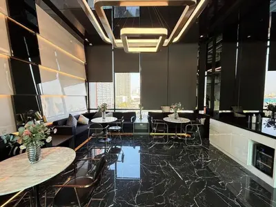 a restaurant with tables and chairs and a couch at 1 bedroom condo, next to BTS Talat Phlu, 0 meters, near Iconsiam, monthly room available in Bangkok