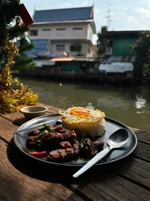 a plate of food on a table next to a river at 1 bedroom condo, next to BTS Talat Phlu, 0 meters, near Iconsiam, monthly room available in Bangkok