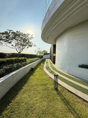 a building with a grassy yard next to a building at 1 bedroom condo, next to BTS Talat Phlu, 0 meters, near Iconsiam, monthly room available in Bangkok