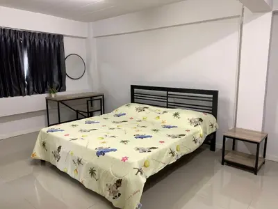 a bedroom with a bed with a comforter and two tables at Ari45 in Bangkok