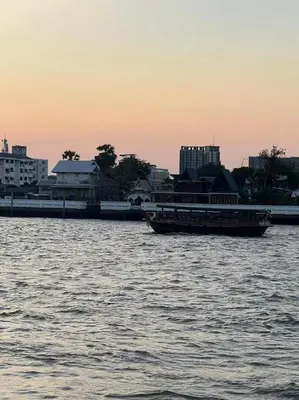 a river with two boats in the water with buildings at JC home \u5218 \u5148 \u751f in Bangkok