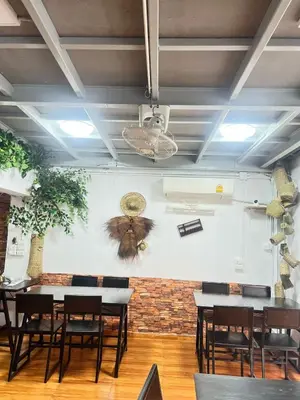 a butterfly on the wall of a restaurant with tables at JC home \u5218 \u5148 \u751f in Bangkok