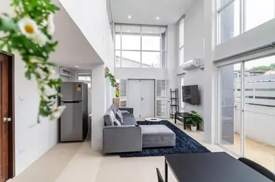 a living room with a couch and a tv at Modern Townhouse City Center 4 Floors 13 Guests in Bangkok