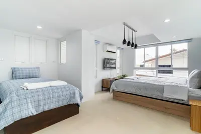 a bedroom with two beds and a window at Modern Townhouse City Center 4 Floors 13 Guests in Bangkok