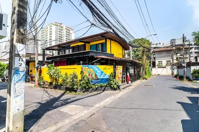 a yellow house on the side of a street at Modern Townhouse City Center 4 Floors 13 Guests in Bangkok