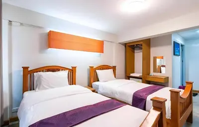 a bedroom with two beds and a mirror at XX GO INN Khaosan - ตรอกข้าวสาร กรุงเทพ in Bangkok