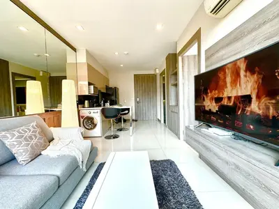 a living room with a large flat screen tv at Bright & Spacious Apartment - Asoke in Bangkok