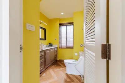 a yellow bathroom with a toilet and a sink at Luxurious 6BR Villa with Pool & Games at Sukhumvit in Bangkok