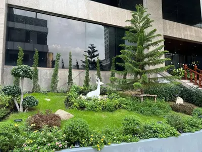 a garden with a white deer in the middle of a building at Elizabeth Hotel in Bangkok