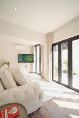 a living room with a white couch and sliding glass doors at Somewhere house in Bangkok