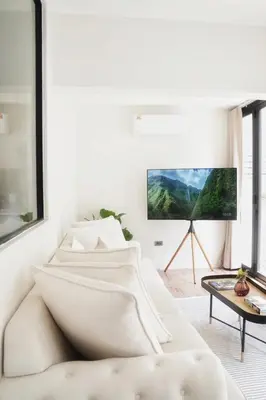 a living room with a white couch and a flat screen tv at Somewhere house in Bangkok